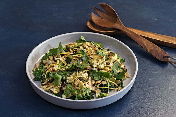 Grilled cauliflower with almonds, kale and currants