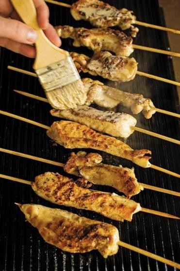 Grilled chicken on a stick with Alabama white barbecue sauce