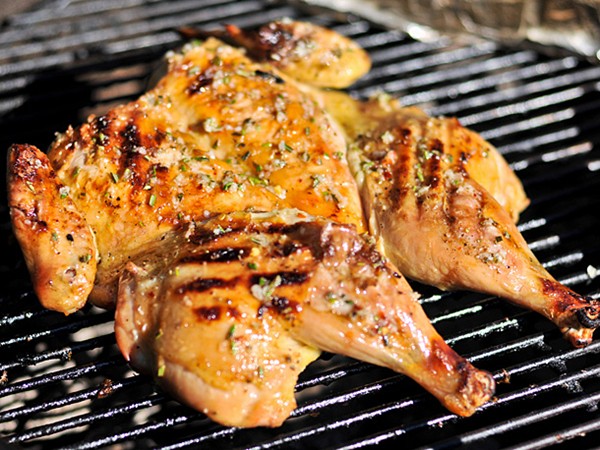 Grilled chicken under a brick with lemon, garlic, and rosemary