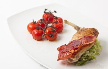 Grilled guinea fowl breast with roasted vine tomatoes and crispy ham