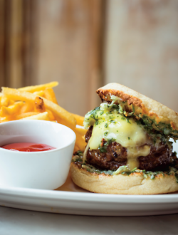 Grilled hamburger with cheddar cheese on toasted English muffin with parsley-shallot butter