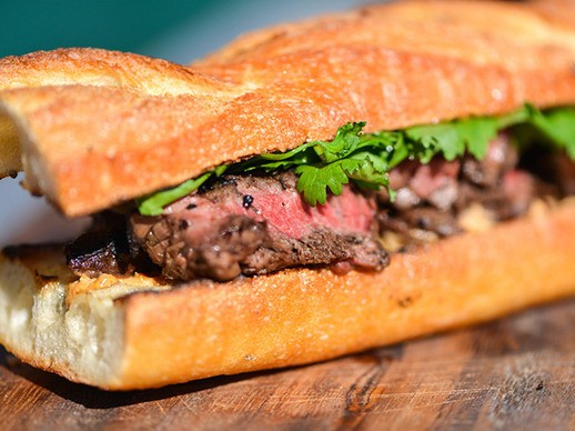Grilled jalapeño-marinated steak sandwiches with charred onions and cotija mayo