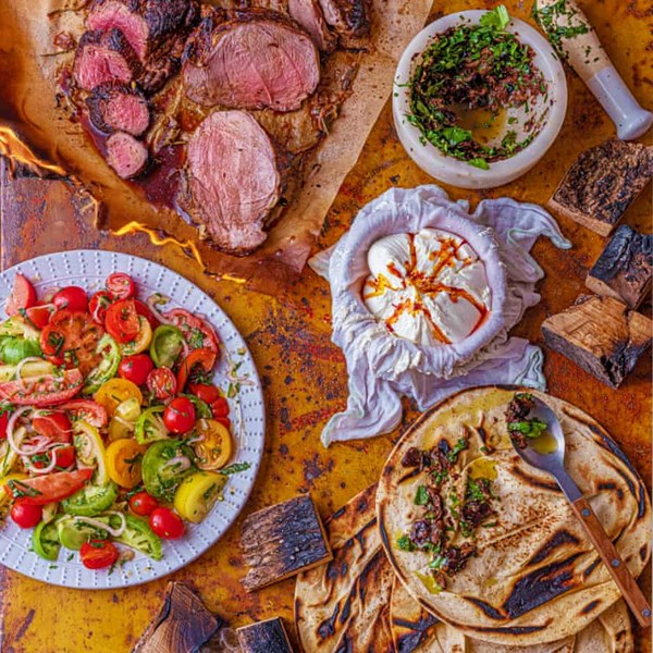 Grilled lamb leg, atom yoghurt, dressed tomatoes, and black olive and anchovy flatbreads
