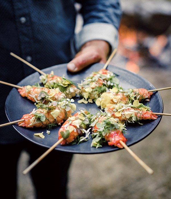 Grilled marron on a stick with citrus butter, flowers and herbs