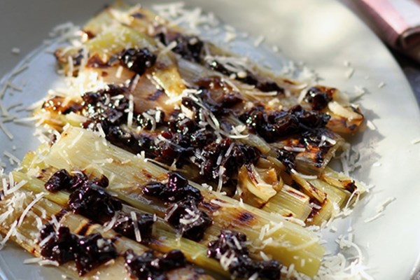 Grilled or seared leeks with shaved sheep's-milk cheese and prunes (Prasa psita me ksismeno tyri kai tzanera)