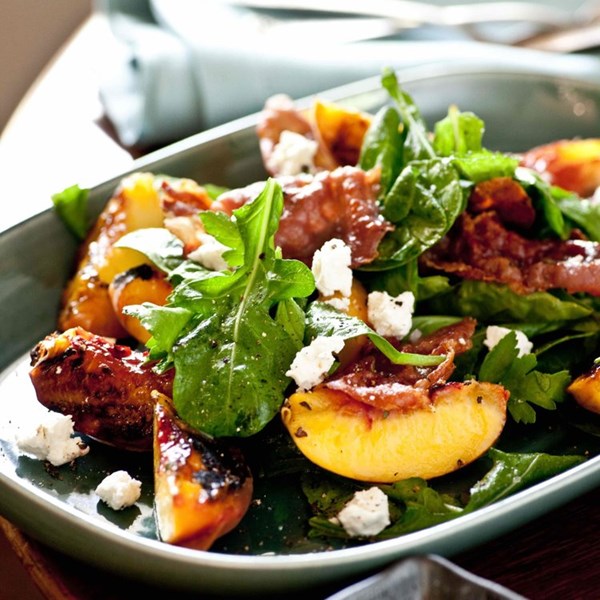 Grilled peach salad with shaved country ham and summer herbs