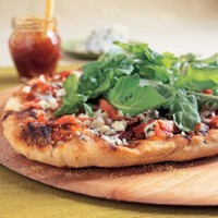 Grilled pizza with fig jam, prosciutto, blue cheese, and arugula