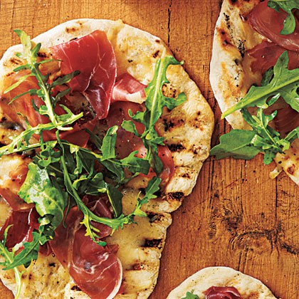 Grilled pizza with prosciutto, arugula, and lemon