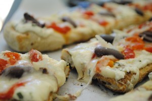 Grilled pizzas with ricotta, roasted peppers, and olives
