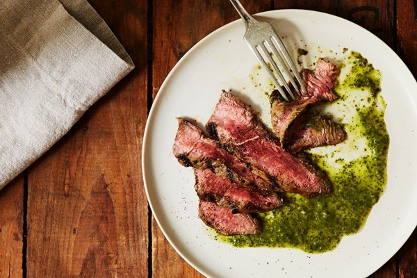 Grilled steak with carrot top chimichurri sauce