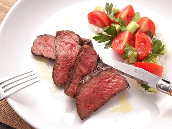 Grilled strip steak with creamy yogurt sauce and tomato-cucumber salad