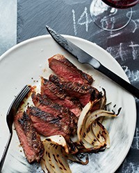 Grilled strip steaks with onion wedges