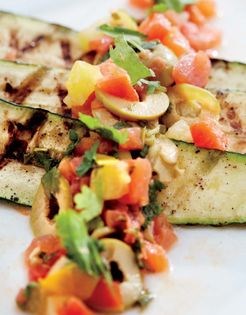 Grilled zucchini with green olives, cilantro, and tomato