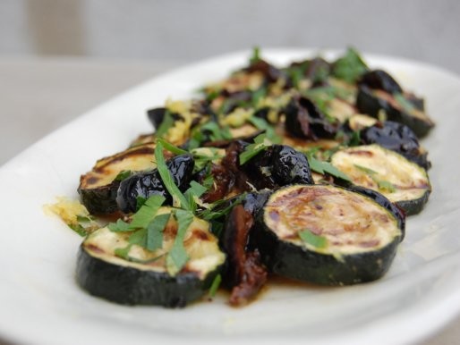 Grilled zucchini with olives, parsley and lemon