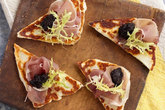 Halloumi crostini with kalamata olive paste, prosciutto, frisée, and lemon zest