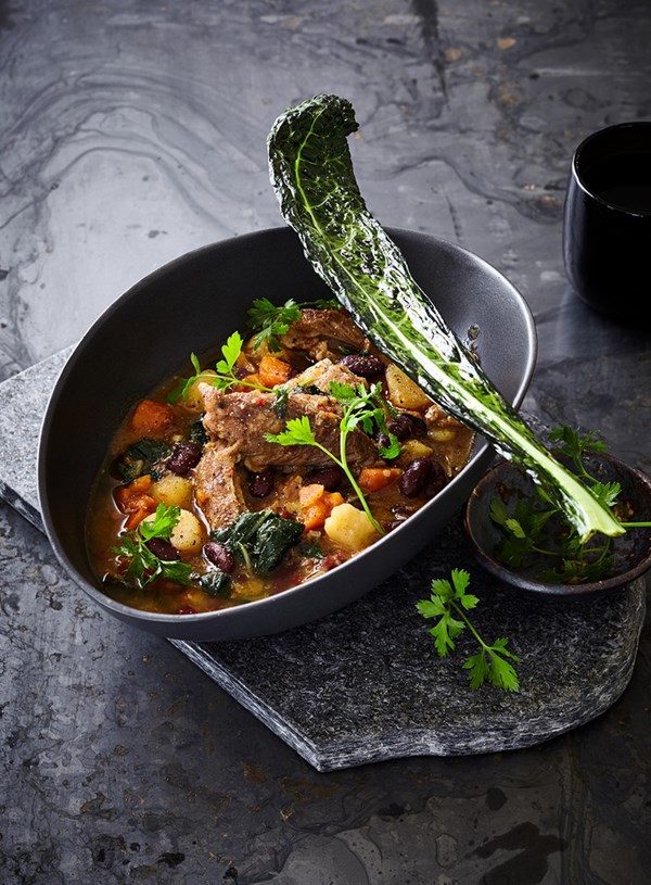 Ham hock and chipotle peppers in adobo sauce soup with red beans and crispy cavil nero