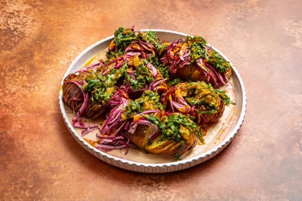 Hasselback shawarma spiced potatoes with tahini sour cream and sumac onions