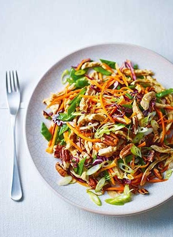 Healthy steamed shredded chicken with crunchy vegetables and yuzu dressing and pecans