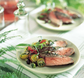 Herb-crusted flank steak with cherry tomatoes and olives