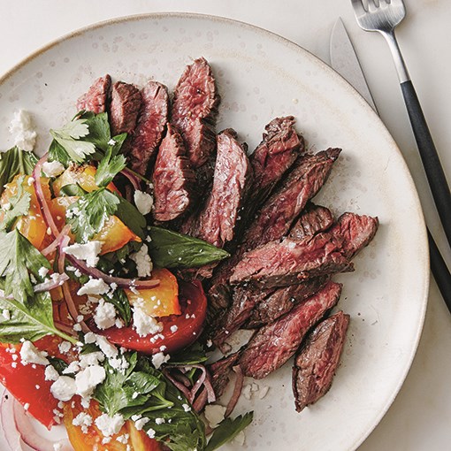 Herb-marinated steak with tomato, onion, and herb salad