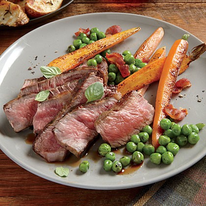 Herb-rubbed New York strip with sautéed peas and carrots