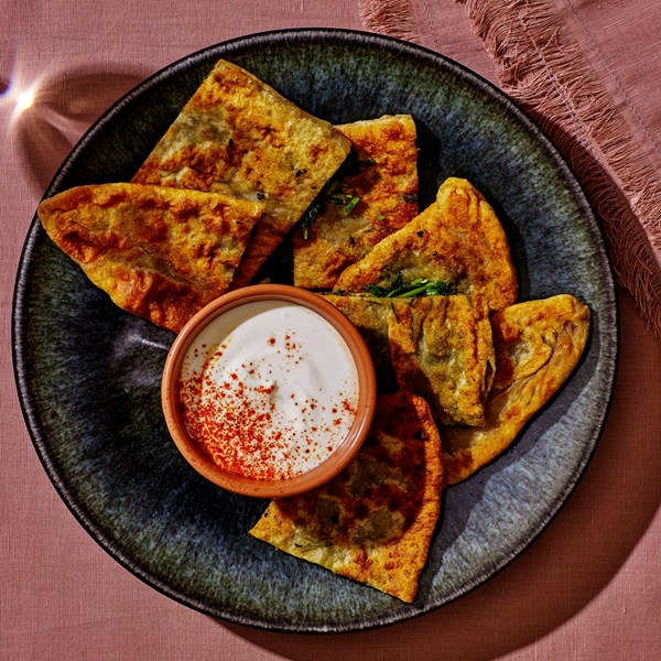 Herb-stuffed flatbreads with yogurt sauce 