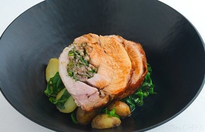 Herb-stuffed pork loin with spring greens and Jersey Royals