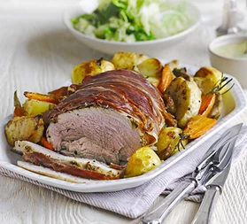 Herby roast pork with veg roasties & apple gravy