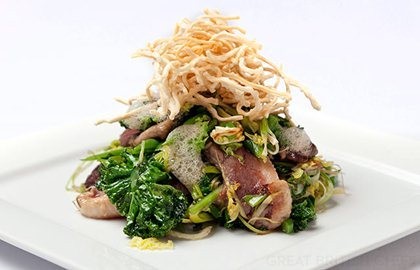 Honey marinated duck breast with sautéed greens and crispy noodles
