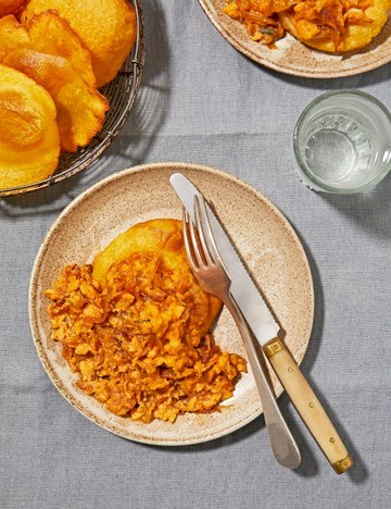 House scrambled eggs over maize flour torto (deep-fried flatbreads)