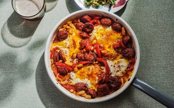 Huevos rotos with chorizo, peppers, white beans and green olive salsa