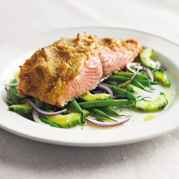 Hummus-crusted Alaskan wild king salmon over a bed of French beans, red onion, and cucumber salad with lemon oil