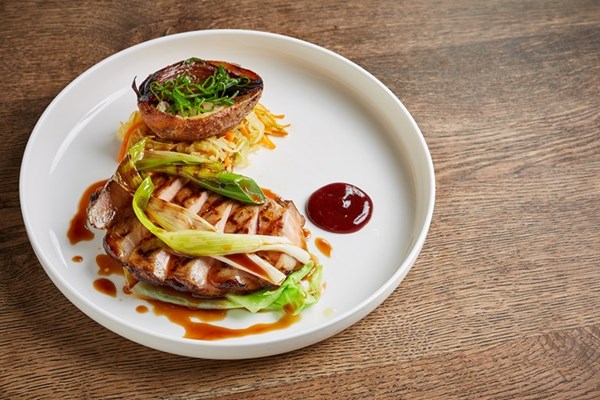 Iberico pork with stir-fried vegetables, crispy potato skins, sweet and sour plum and spring onions