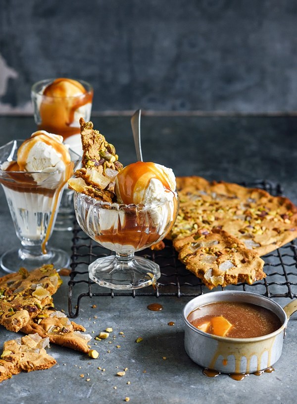 Ice cream sundae with crumbled ginger and pistachio biscuit and ginger caramel sauce