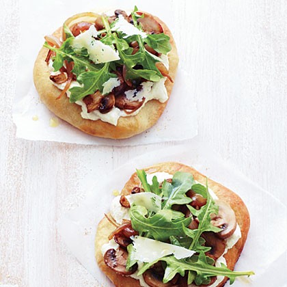 Individual mushroom, onion, and arugula pizzas