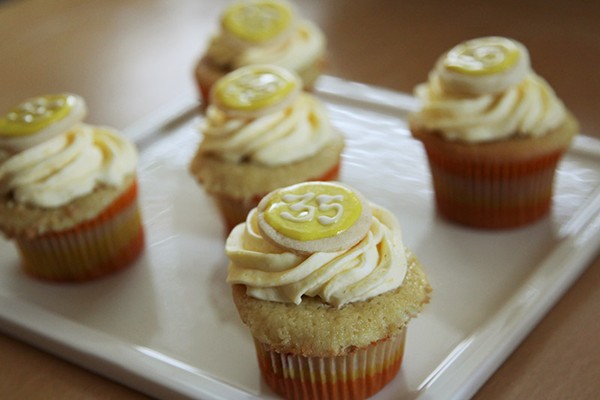 Italian cream cupcakes with lemon curd filling and lemon buttercream, with a sugar cookie decoration on top
