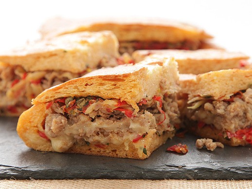 Italian sausage and Fontina shooter's-style sandwich with onions, peppers, fennel, and sun-dried tomato-caper relish