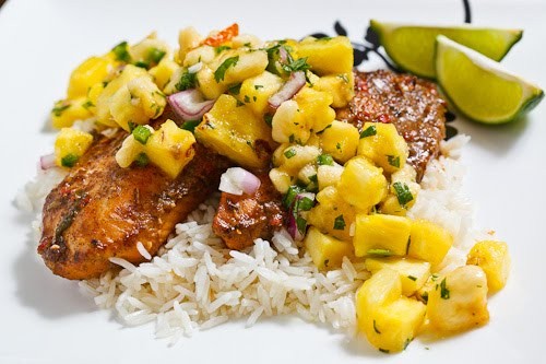 Jerk fish on coconut rice topped with banana and pineapple salsa