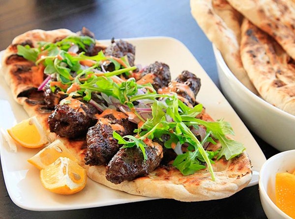 Kofte kebabs with spicy harissa yogurt sauce and grilled flatbread (Minced lamb kebabs)