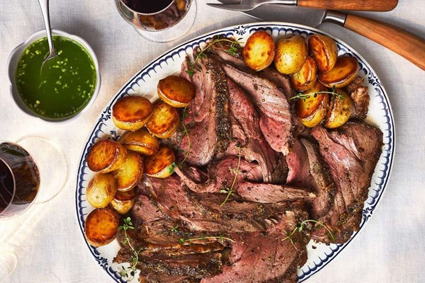 Leg of lamb cooked over new potatoes with spicy mint-rum sauce