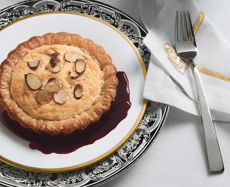 Lemon soufflé tartlets with sugared almonds and blackberry sauce