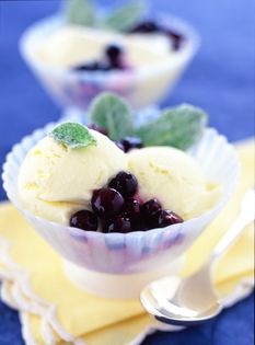 Lime ice cream with blueberries and sugared mint leaves