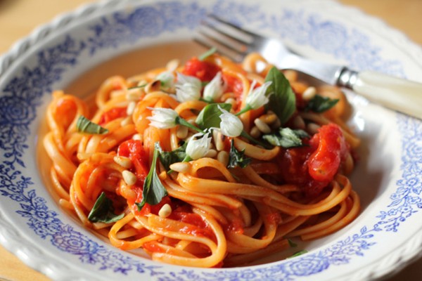 Linguine with a simple tomato sauce, wild garlic flowers and pine nuts