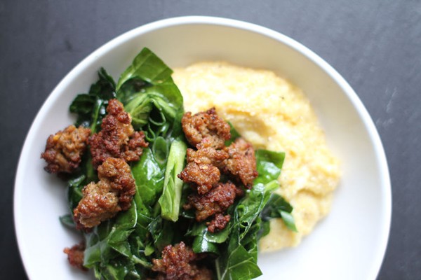 Marinated collard green salad with sausage over Gruyere grits