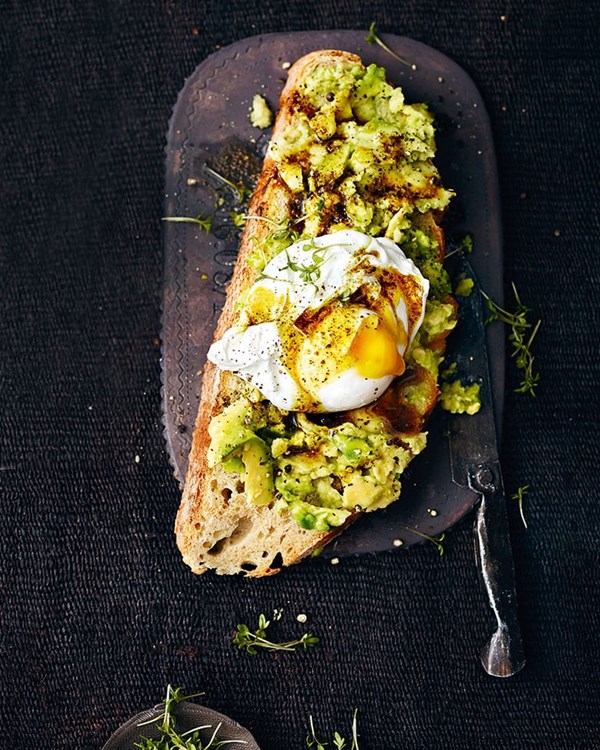 Mashed avocado and poached egg on toast with curried butter