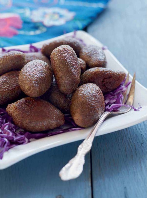 Meat and bulgur spheres stuffed with lamb-pine nut filling (Kibbeh kbekib)