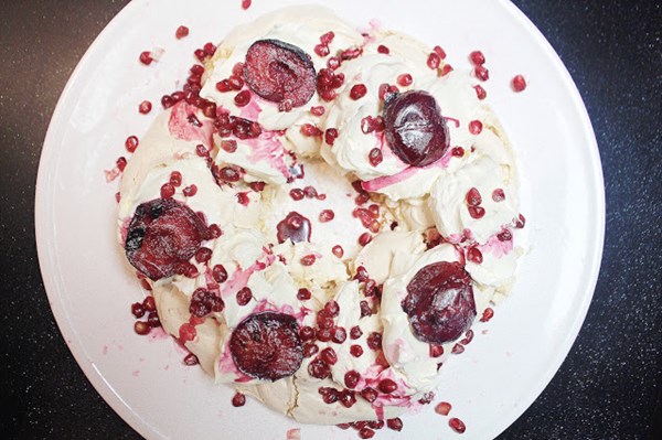 Meringue wreath with mulled plums and pomegranates