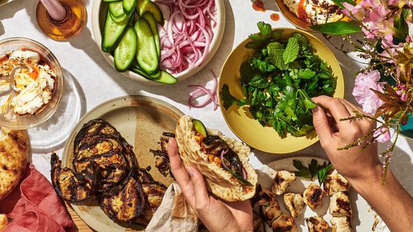 Meze spread [quick-pickled red onion; grilled chicken skewers; grilled tahini eggplant; harissa chickpeas; seasoned labneh]