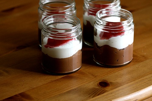 Milk chocolate pudding with cream and raspberry sauce