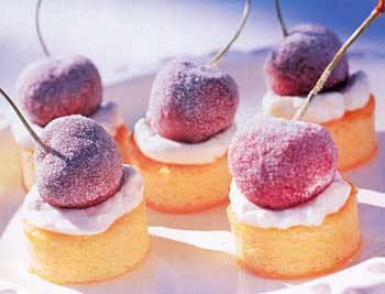 Miniature almond cakes with sugared cherries and kirsch cream